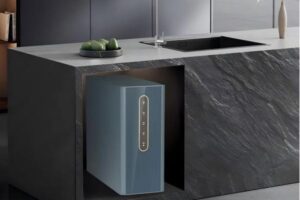A modern, compact water purifier on a stylish apartment kitchen counter